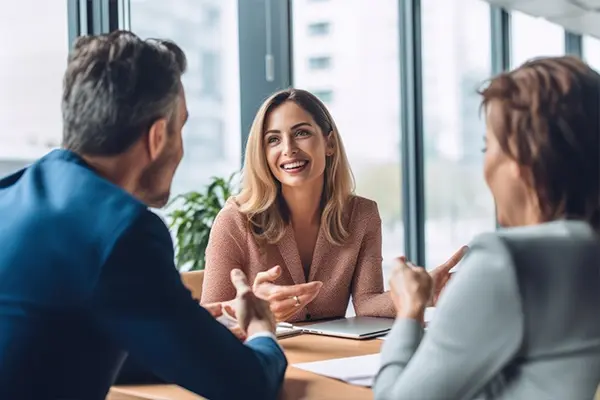 Three professionals engaged in a collaborative meeting with Kraft Analytics.