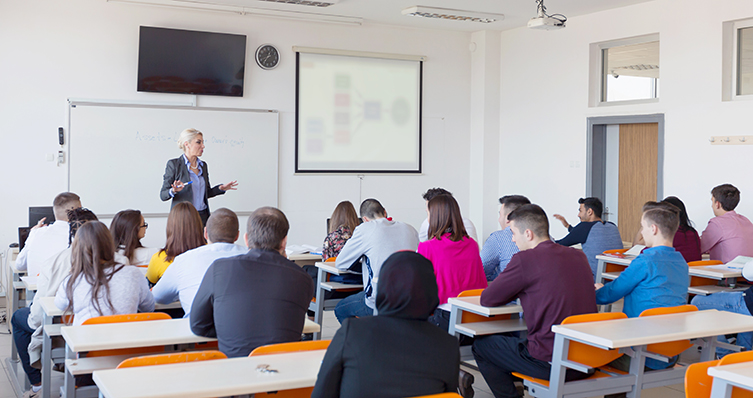 A woman instructs students in her classroom.