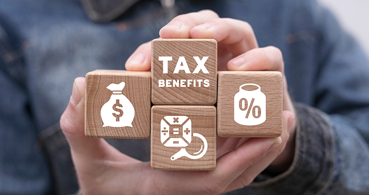Man holding wooden blocks with icons and sees inscription: TAX